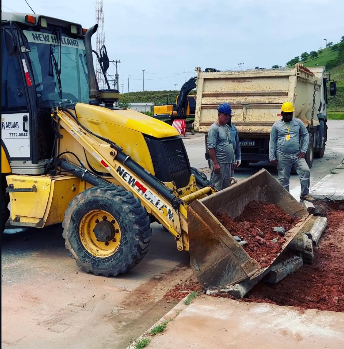 Equipe E.R Aguiar operando retroescavadeira