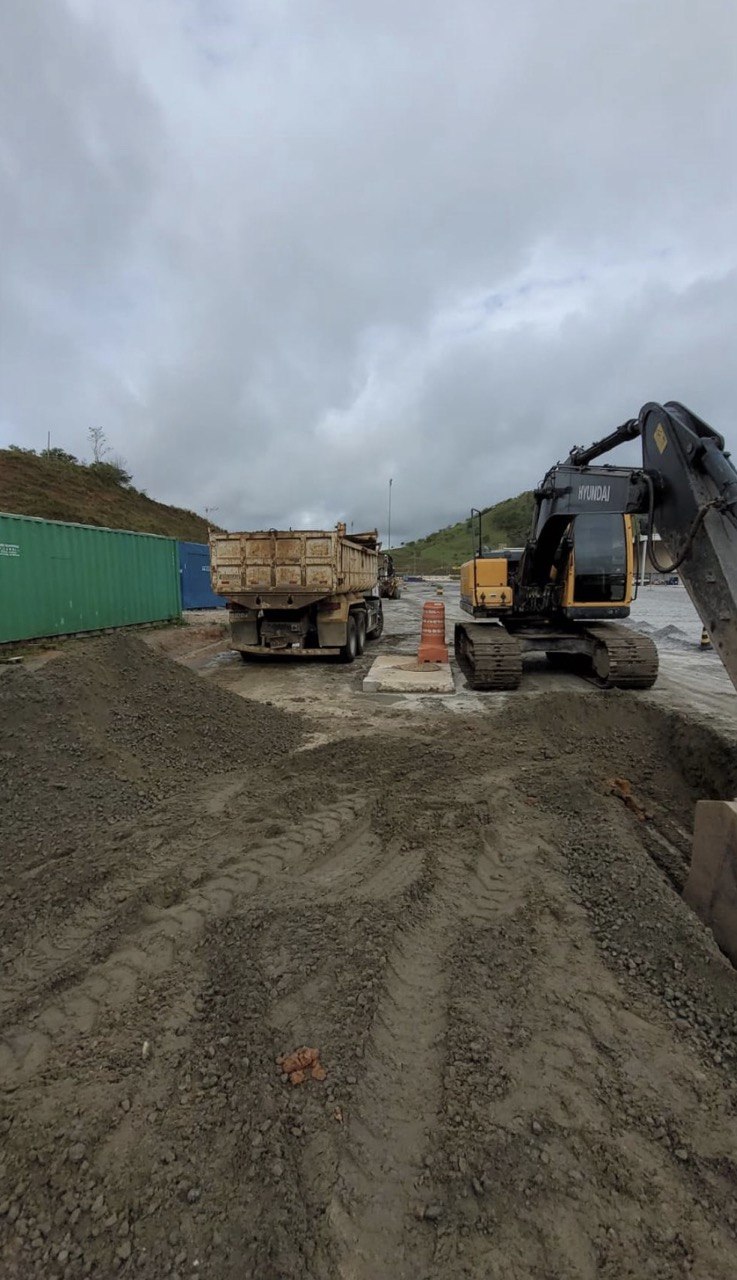 Escavadeira Hyundai e caminhão basculante em obra de terraplanagem