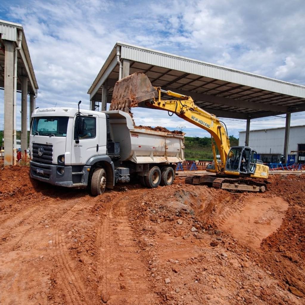 Escavadeira carregando caminhão basculante em obra