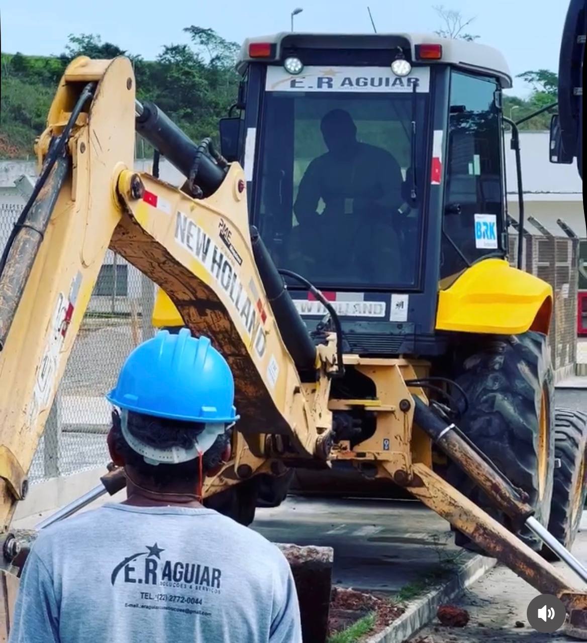 Operador conduzindo retroescavadeira E.R Aguiar